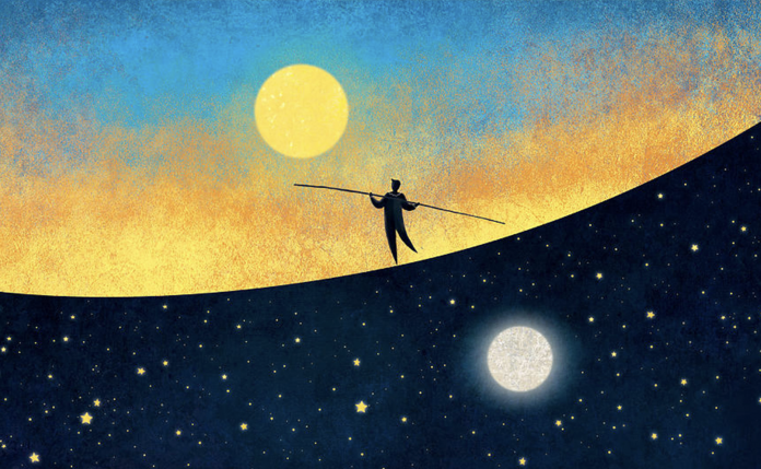 uomo in equilibrio con luna e sole sullo sfondo