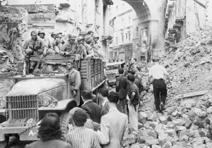 Soldati su un carrro e persone civili tra le macerie